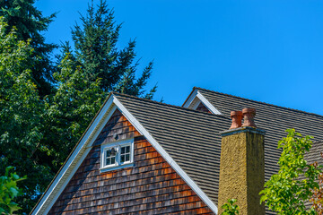 Obraz premium A perfect neighborhood. Houses in suburb at Summer in the north America. Top of a luxury house with nice window over blue sky.