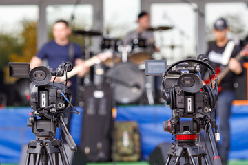 two cameras on tripods are installed during the concert