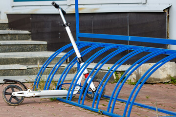 an ordinary scooter for children in the parking lot at the store