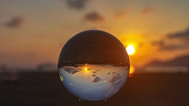 The view in a crystal ball looks like no other. 4K Videos for beautiful and unusual travel ideas..time lapse clouds moving in beautiful sky in sunrise above the sea.