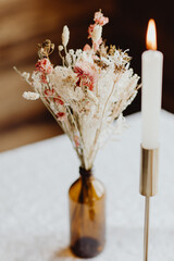 Fototapeta na wymiar Bougie et fleurs séchées pour la décoration de la table du maraige