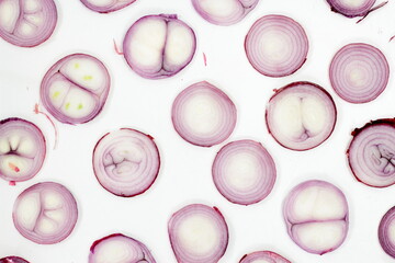 Red onion ring slices on white background. Fresh raw round veggie geometric background from purple onion. Top view or flat lay