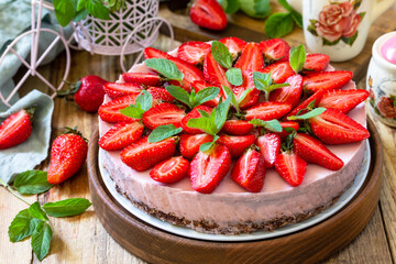 Summer diet dessert without baking Gluten-free, birthday menus. Strawberry cheesecake on a granola with fresh strawberries on a on rustic wooden table.