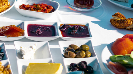 Turkish traditional breakfast served items: nuts, olives,berry jams, butter