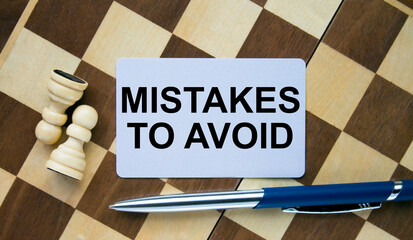 Business card with text Mistakes To Avoid on a chess board with pen and eyeglasses