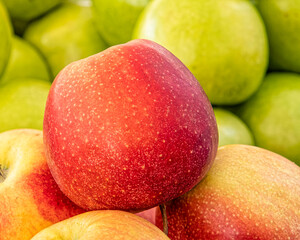 a red apple on green apple's background, fresh vegetarian food