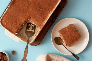Tiramisu and coffee on a blue background.