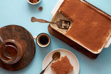 Tiramisu and coffee on a blue background.