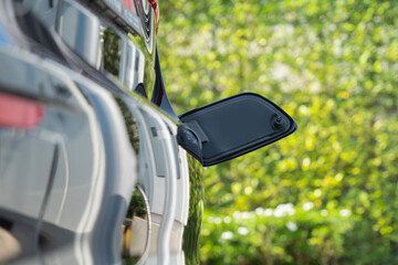 Hand plugging in EV car charger or electric vehicle. Cable connect to gas station,power supply...