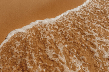 Areia e água do mar com onda batendo