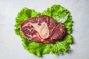 Ossobucco steak with herbs on a white plate. top view.