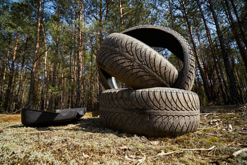 old tire in the forest, pollution of nature car tires