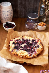 Blueberry, frangipane galette. Side view. Wooden background.