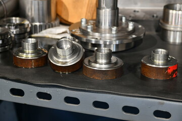 Metal grips and threaded adapters in a repair shop.