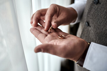 man holding wedding rings, groom getting ready in the morning before ceremony