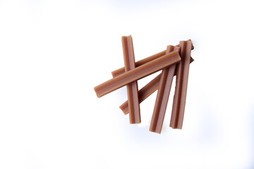 pets food concept - chews - dental sticks for dogs isolated on white background flat lay