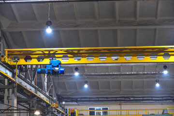 An overhead crane in a workshop at a factory, operated by a cran