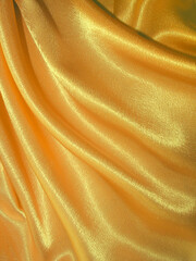 Beautiful draped golden silk fabric background. Fabric texture - 427525268