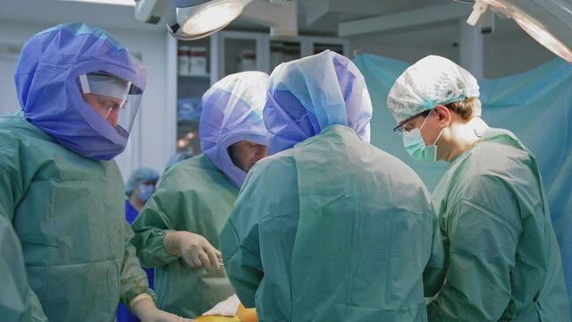 Operating room with surgery in progress. Medical team performing surgical operation in bright modern operating room