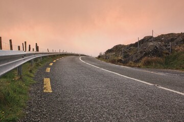 Narrow uphill rural road in Ireland and orange sky