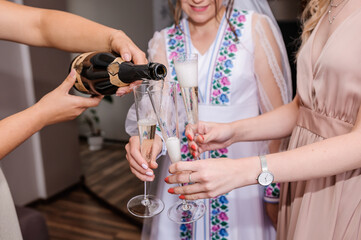 Glasses with white wine in the hands of the girls. Wine glasses in the hands of the bride and...