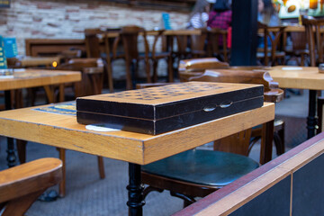 Closed chess board on a table in an empty terrace of a street cafe in Istanbul, Turkey. Loss of visitors and business during pandemic. Selective focus, blurred background