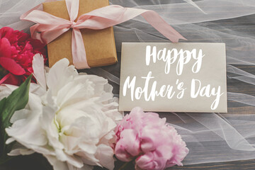 Happy mother's day. Happy mother's day text on card and beautiful peony bouquet, gift box on soft...