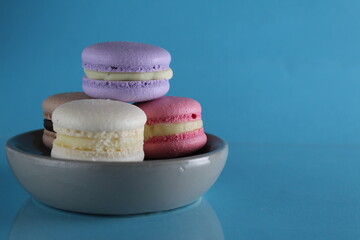 Macaroons lavender vanilla chocolate coffee pink on a gray plate on a blue background with a place...