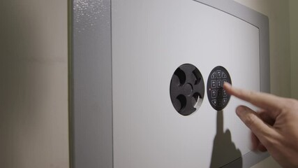 The man enters the password on the door of the safe and takes the gun from there