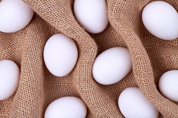 White eggs on a wrinkled woven cloth.