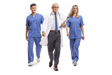 Fototapeta premium Full length portrait of a doctor with a male and female nurse walking