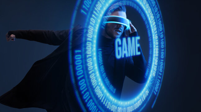 Man on dark virtual reality background. Guy using VR helmet. Augmented reality, future technology, game concept. Blue neon light. Futuristic holographic interface to display data.