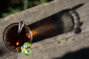 Cup of tea and wild strawberries on a wooden background
