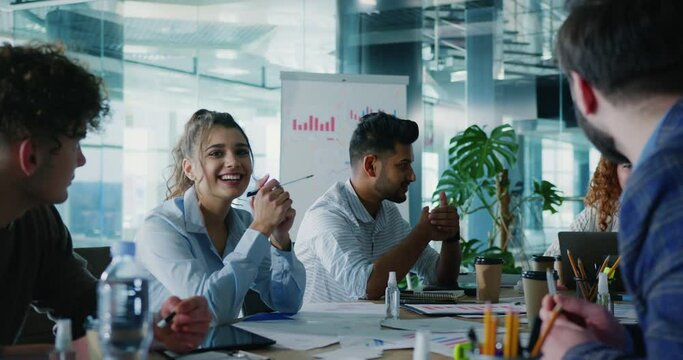 Close up of diverse colleagues discussing business ideas with company manager. Team of multicultural students having training seminar with female mentor.