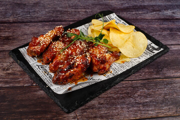 Baked chicken wings with sesame and sauce. Food background with copy space.