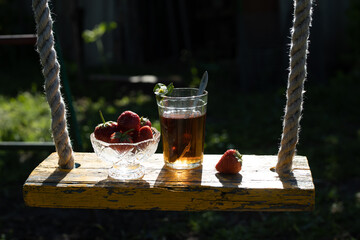Cup of tea and wild strawberries on a wooden background