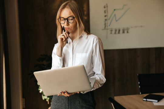 Pensive Business Woman Working At A Laptop, Thinking About A Heavy Task, Office Work.