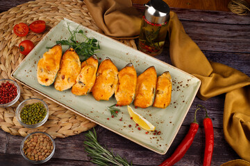 butter garlic fried shrimp sprinkled with chili and parsley on a white platter, on a wooden table