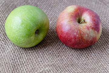 ripe juicy red and green apples on burlap cloth close up