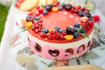 Cheesecake with berries on the picnik in the park.W eading cake on table in the park