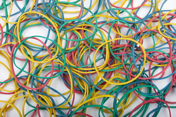 Top view of stationery multicolored rubber bands on a white background.