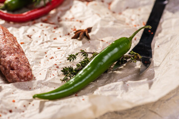 Assorted peppers and spices on a light parchment background. Seasonings for food. Homemade spices...