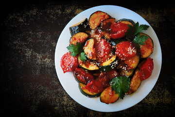Baked vegetables with sesame seeds on a white plate. Vegan lunch. Healthly food.