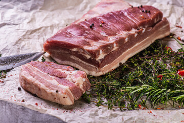 Raw fresh beef ribs steak with seasoning on a light surface, parchment, before cooking. Seasoning for meat steak with ribs for eyes rosemary, coriander, pepper. Top view, lying flat