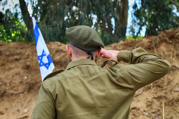 Israeli soldier salutes the Flag of Israel. Concept: Israel Remembrance Day, Israel Independence...