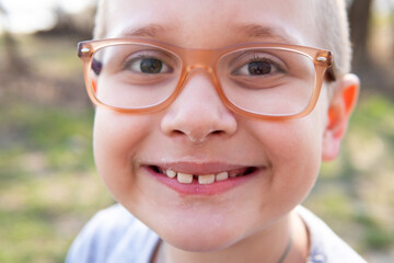 smiling boy with glasses in nature