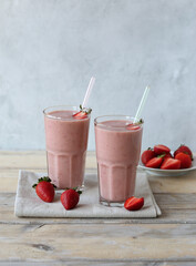 Strawberry smoothies in glasses and strawberries on a wooden table. Vegan and healthy breakfast.
