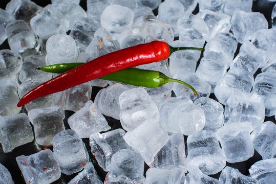 Red hot pepper with ice cubes on cold and wet ice. Sharp and cold. Selective focus - Powered by Adobe