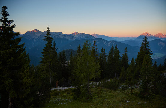 Sunrise in the Karwendel mountains. This feels like a vacation. Do you want to go out again in a new environment? Fir trees in the foreground. Normal perspective. 