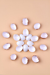 Vertical shot chicken egg shells arranged in a round shape on beige background.